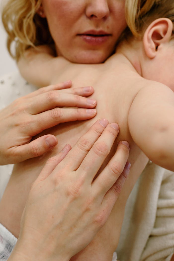 Close-up of a mother giving a gentle massage to her baby, showcasing tender care.